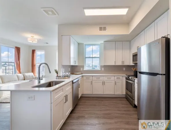 a kitchen with stainless steel appliances white cabinets white stove a microwave and a refrigerator