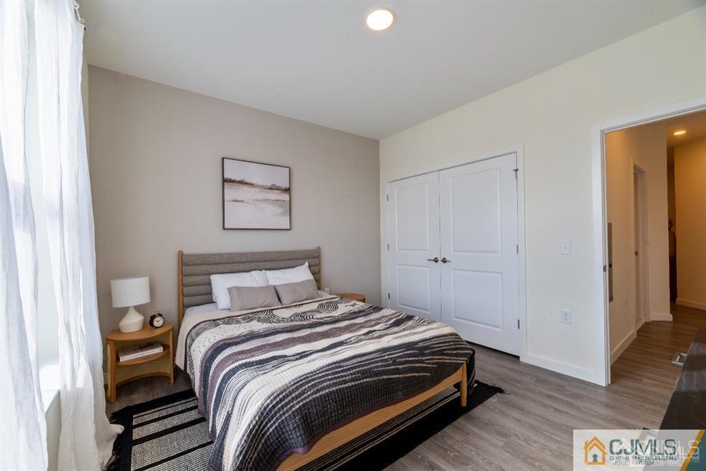 1 Nolan Way, Unit B32F North Brunswick, NJ 08902 - Photo 21 of 82 a bedroom with a bed and a painting on the wall