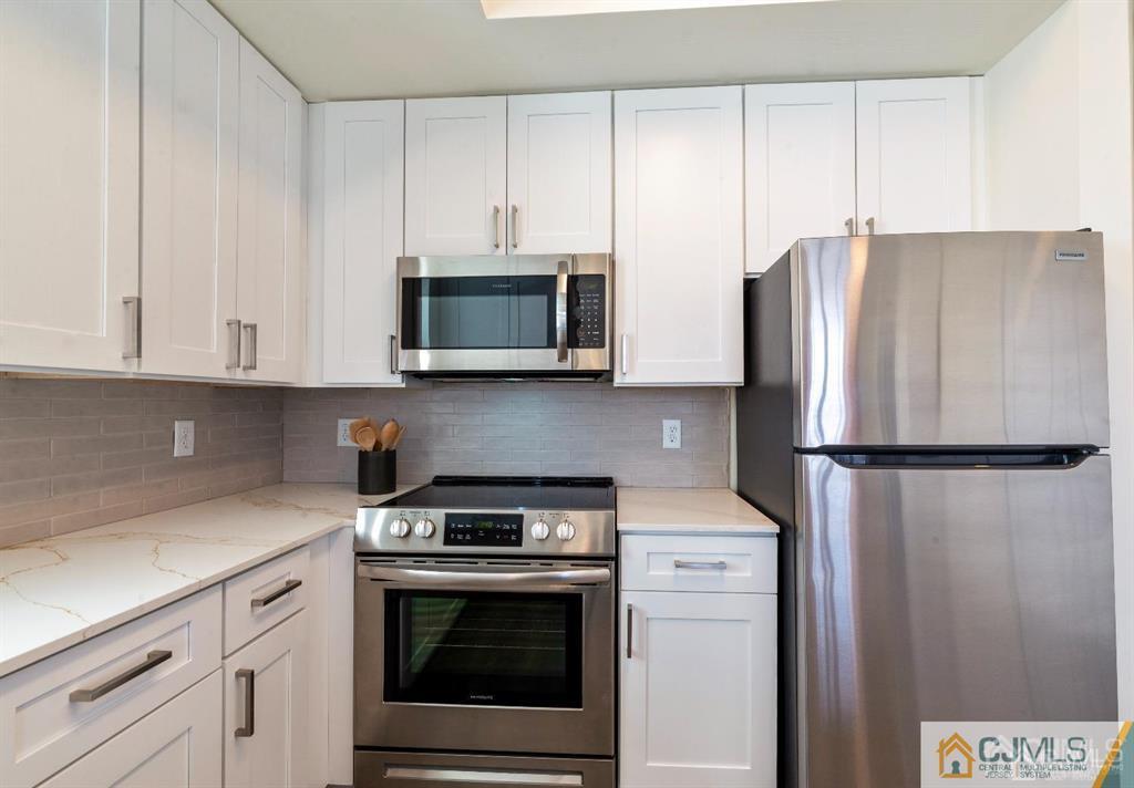 1 Nolan Way, Unit B32F North Brunswick, NJ 08902 - Photo 3 of 82 a kitchen with stainless steel appliances white cabinets white stove a microwave and a refrigerator