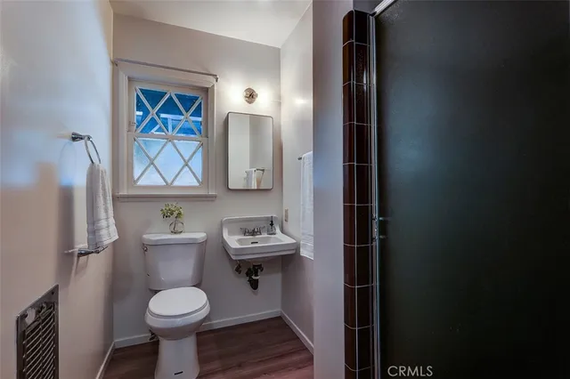 a bathroom with a toilet a sink and mirror