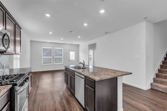 a kitchen with kitchen island a sink stove and wooden floor