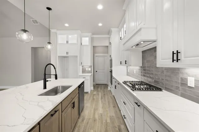 a kitchen with stainless steel appliances granite countertop a sink stove and cabinets