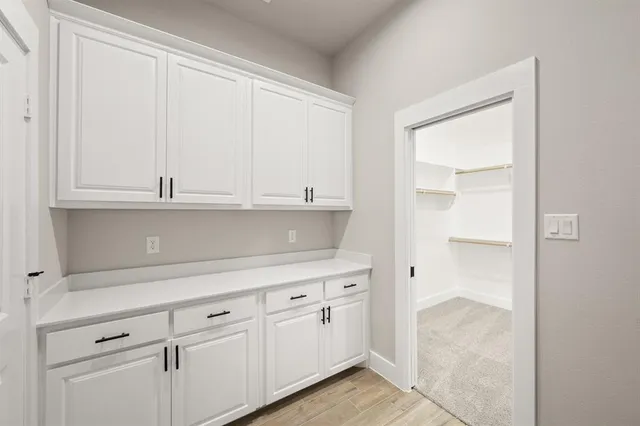a kitchen with white cabinets and white appliances