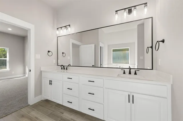 a bathroom with double sink and a mirror