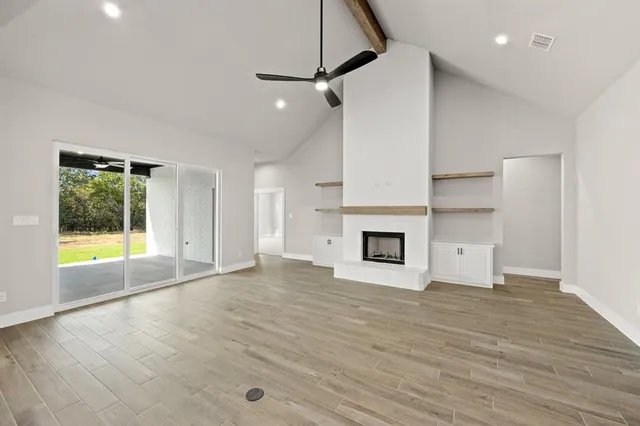 a view of empty room with wooden floor and fireplace