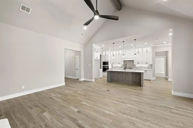 a large kitchen with kitchen island a sink stainless steel appliances and cabinets