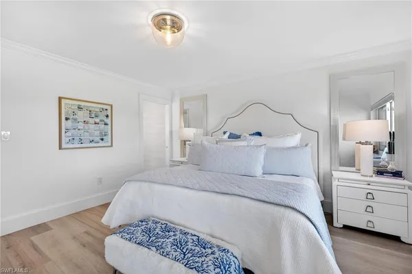 a bedroom with a white bed and a chandelier