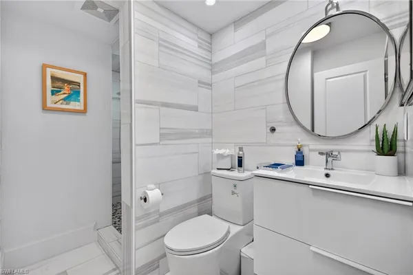 a bathroom with a toilet a sink and mirror