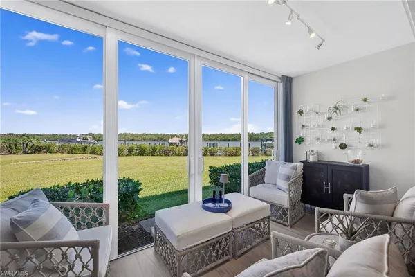 a living room with furniture and a floor to ceiling window
