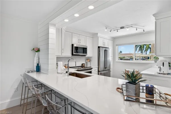 a kitchen with a table a microwave and cabinets