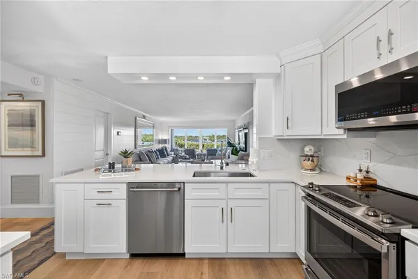 a kitchen with white cabinets stainless steel appliances and sink
