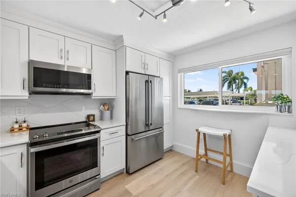 a kitchen with stainless steel appliances a stove microwave and refrigerator