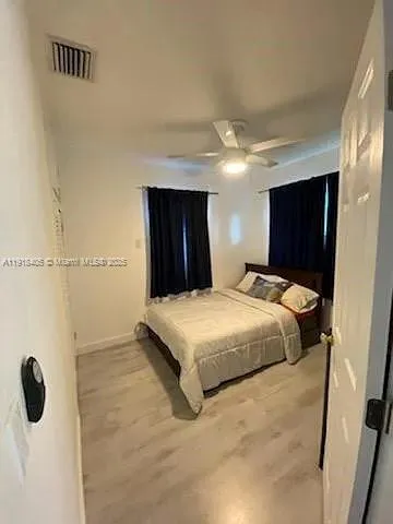 a bedroom with a bed and a ceiling fan