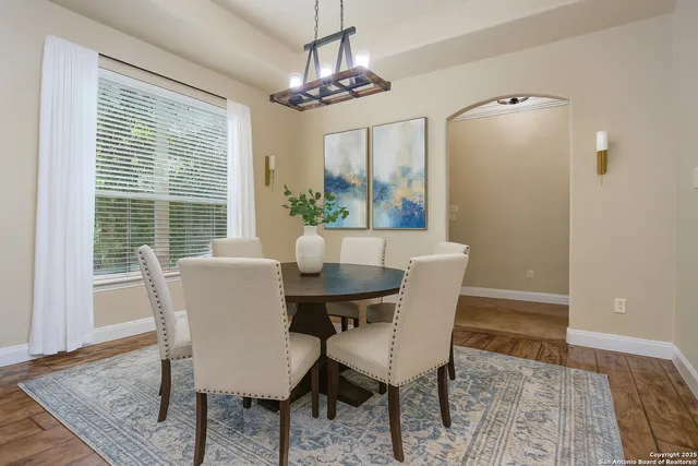 a view of a room with wooden floor a ceiling fan and a chandelier
