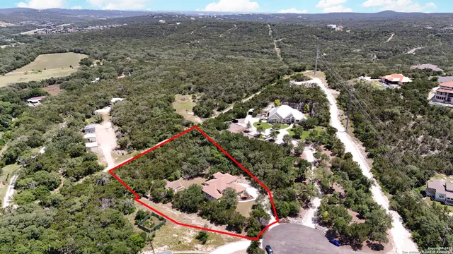 an aerial view of house with yard and mountain view in back