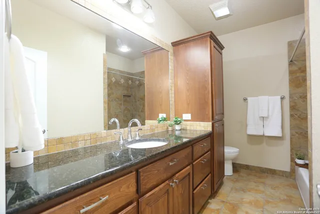 an empty room with a chandelier fan and windows