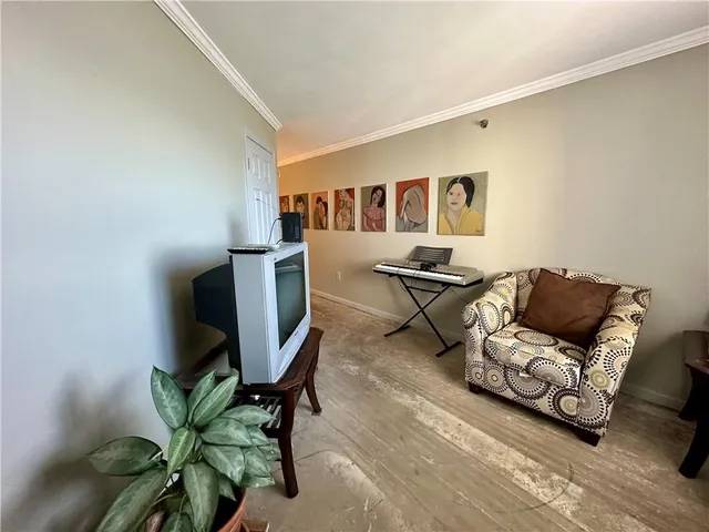 a view of a hallway with couches and wooden floor