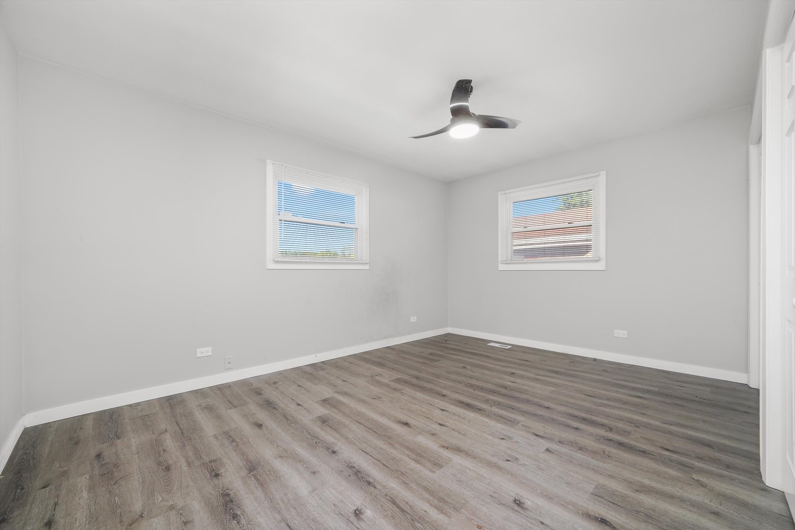 1011 East 142nd Street Dolton, IL 60419 - Photo 19 of 21 an empty room with wooden floor chandelier fan and windows