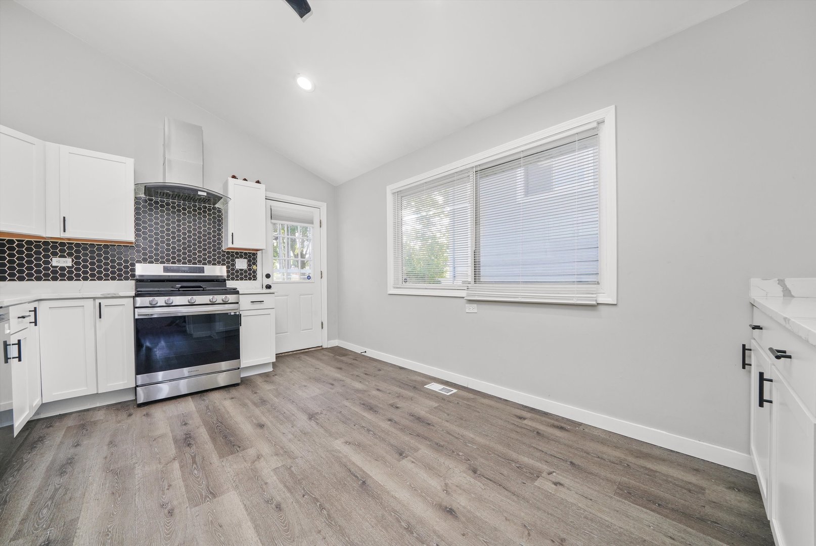 1011 East 142nd Street Dolton, IL 60419 - Photo 8 of 21 a kitchen with granite countertop a stove top oven and cabinets