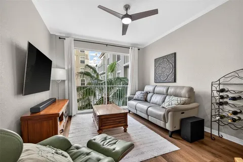 a living room with furniture a flat screen tv and a large window