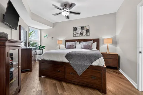 a bedroom with a bed a flat screen tv and dresser