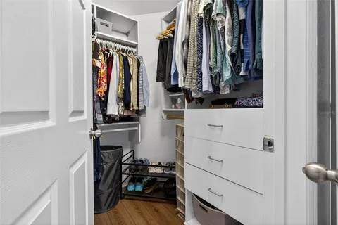 a view of walk in closet with clothes and shoes