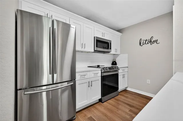 a kitchen with stainless steel appliances a refrigerator sink and microwave