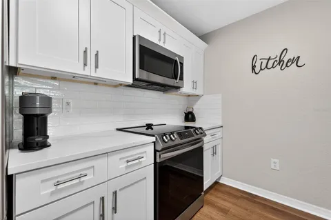 a kitchen with stainless steel appliances granite countertop a stove a microwave and cabinets