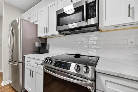 a kitchen with stainless steel appliances granite countertop a refrigerator and a stove