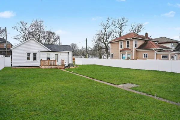 a view of a house with a big yard and large trees