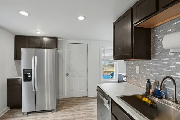 a kitchen with stainless steel appliances a refrigerator a sink a stove and cabinets