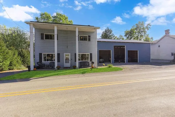 front view of a house with a yard and an trees