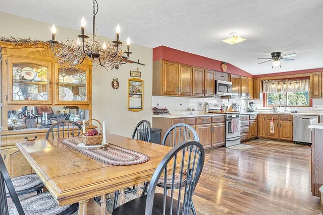 a kitchen with stainless steel appliances kitchen island granite countertop a kitchen island a stove a table and chairs