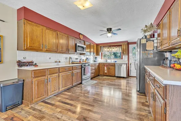 a large kitchen with stainless steel appliances granite countertop a stove a sink dishwasher and a refrigerator