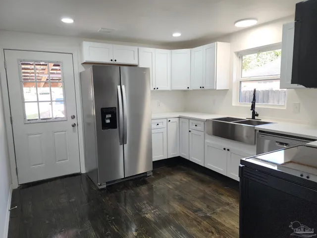 a kitchen with a refrigerator sink and cabinets