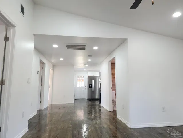 a view of a hallway with wooden floor and windows