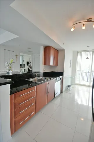 a kitchen with granite countertop a sink and a stove top oven