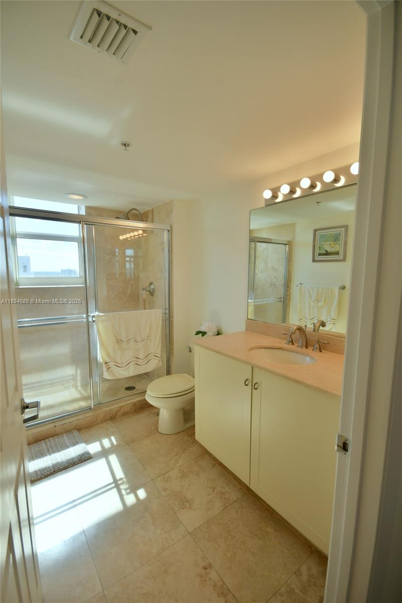 3232 Southwest 22nd Terrace, Unit 1502 Miami, FL 33145 - Photo 35 of 45 a spacious bathroom with a shower a mirror and a sink