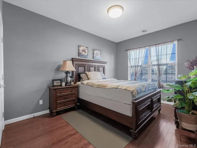 a spacious bedroom with a bed and a potted plant