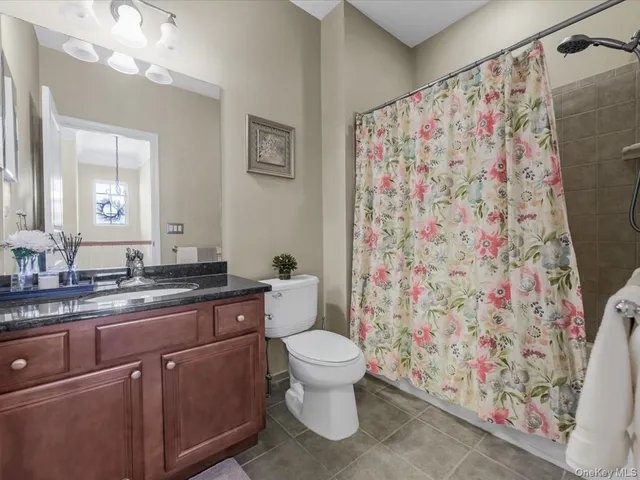a bathroom with a granite countertop sink a toilet and a mirror