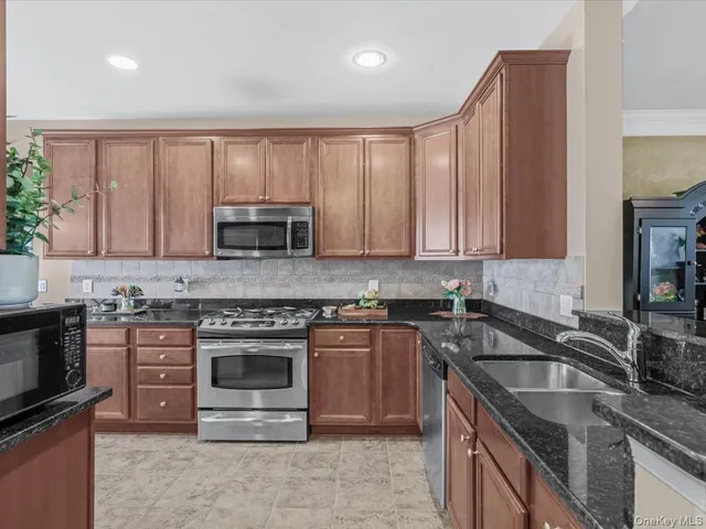 a kitchen with granite countertop a stove sink and cabinets