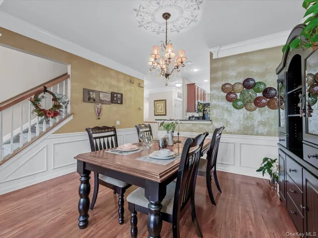 a view of a dining room with furniture wooden floor and chandelier