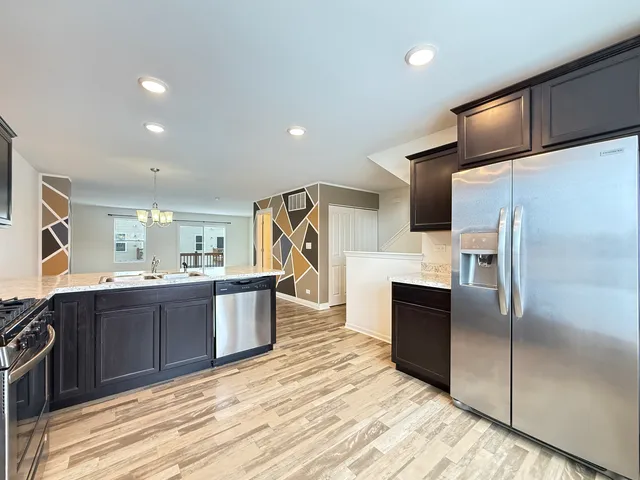 a large kitchen with a large counter top stainless steel appliances and cabinets