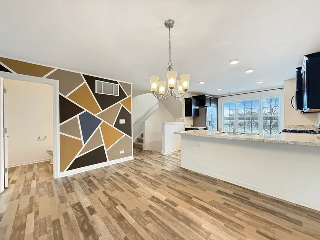 a room with wooden floor a ceiling fan and a rug