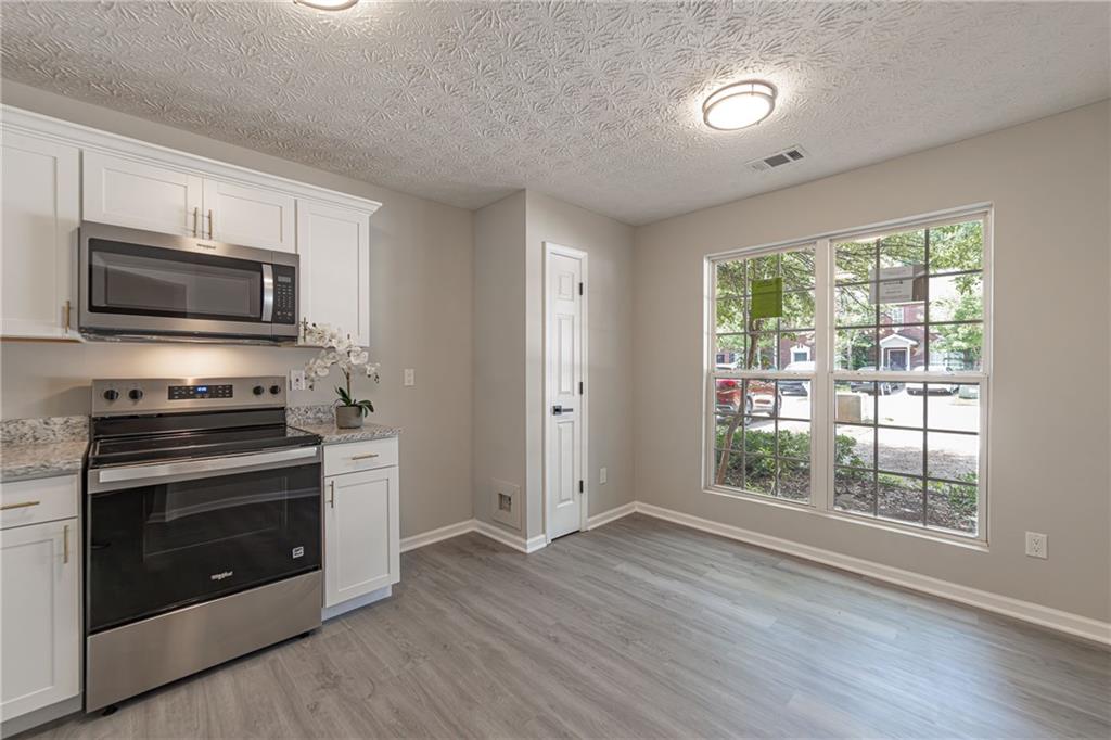 3017 Waldrop Circle Decatur, GA 30034 - Photo 11 of 52 a kitchen with wooden floors and stainless steel appliances