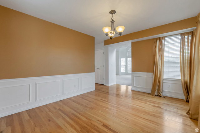 11079 Ohenry Road East Sandy, UT 84070 - Photo 6 of 26 Hardwood flooring with wainscoting and a three-light chandelier