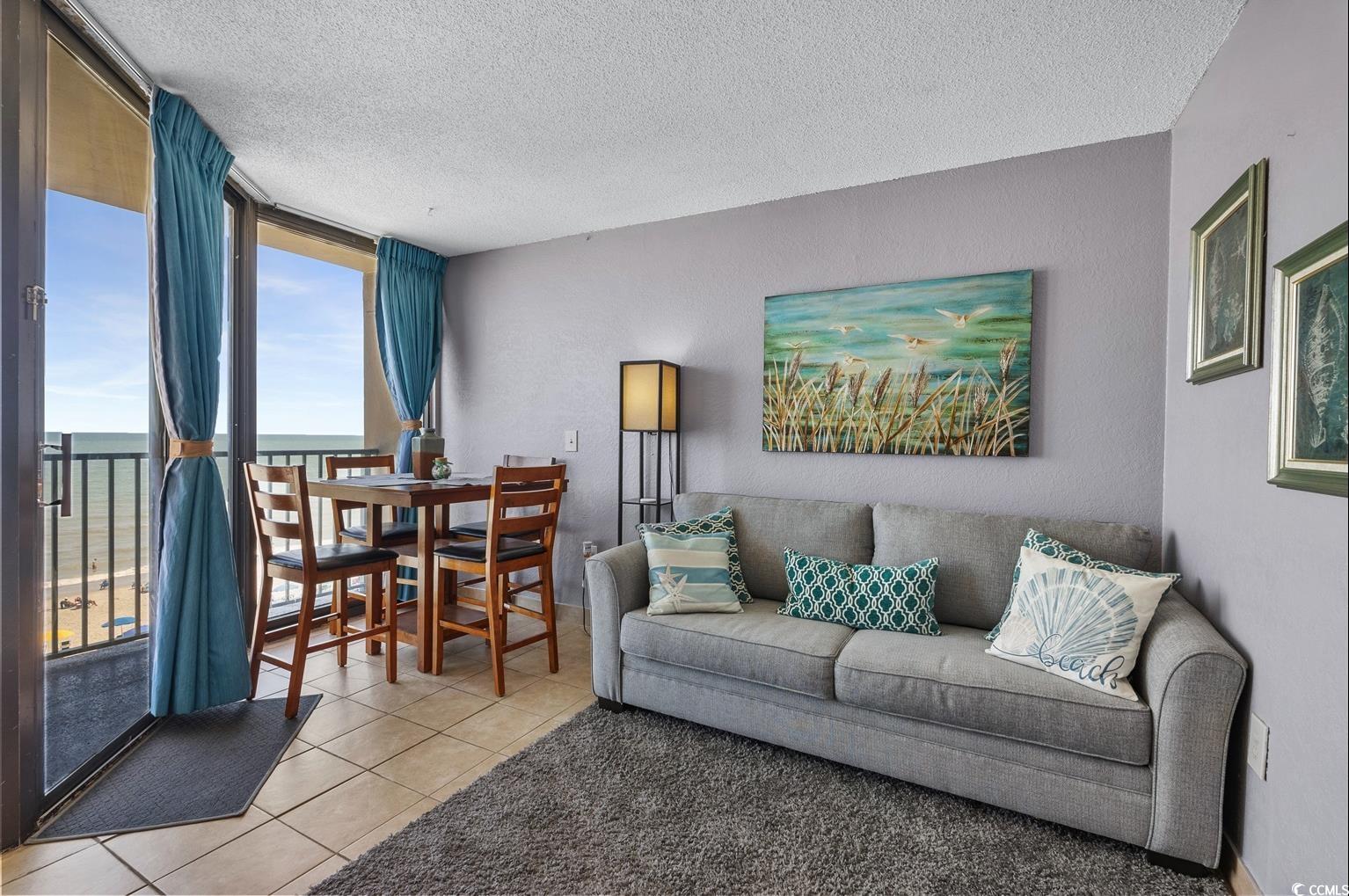 201 74th Avenue North, Unit 2527 Myrtle Beach, SC 29572 - Photo 11 of 18 Living area featuring a textured ceiling, light tile patterned floors, floor to ceiling windows, and a textured wall