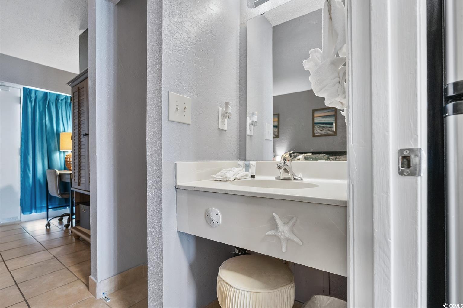 201 74th Avenue North, Unit 2527 Myrtle Beach, SC 29572 - Photo 8 of 18 Bathroom featuring a textured wall, vanity, and light tile patterned floors