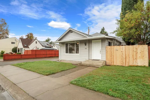 a front view of a house with a garden and yard