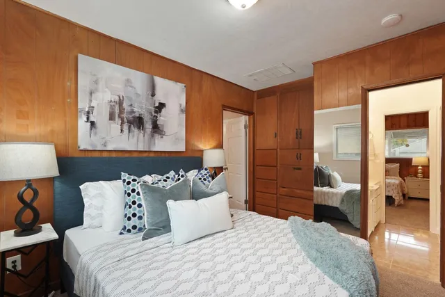 a bedroom with a bed and a painting on the wall